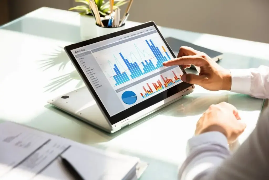close up of a tablet screen with bar graphs and pie charts illustrating analytics