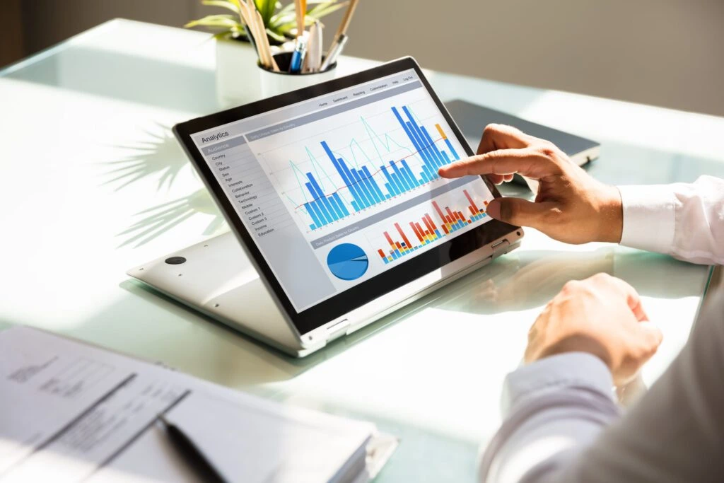 close up of a tablet screen with bar graphs and pie charts illustrating analytics